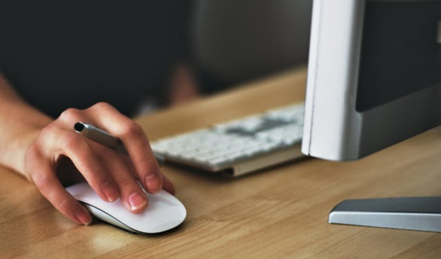 Close-up of a hand using a computer mouse next to a keyboard, symbolizing the individuality of job searches